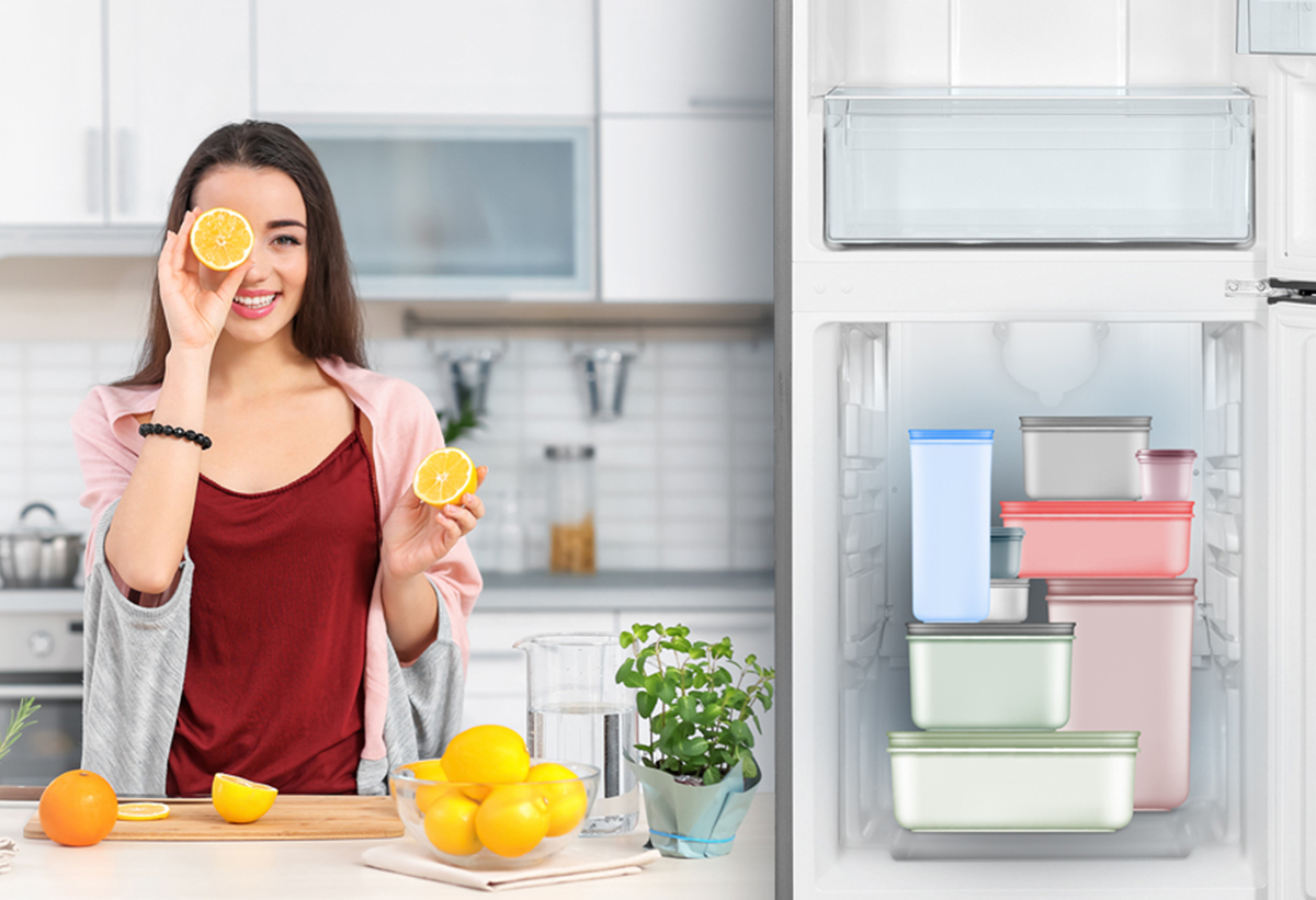 Παρουσιάζει μία γυναίκα στην κουζίνα με λεμόνια και το ψυγείο με ανοιχτές πόρτες και την ευκολία χώρου στην κατάψυξη.